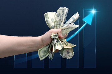 Dollar banknotes in human hand on arrow background