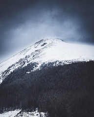 High Tatras, Mountain covered with snow with dark clouds.