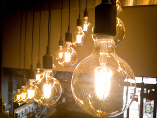 Closeup image of incandescent light bulbs glowing under the ceiling