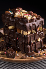 handmade chocolate cake with nuts and raisins in a ceramic plate.