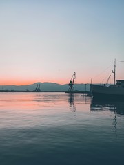 Fototapeta na wymiar Silhouettes of the cranes in the sea port
