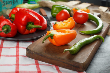 Variety of chili peppers on a wooden board.
