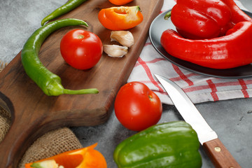 Mixed vegetables on a wooden board with a knife.