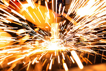 Bright flash from an industrial laser that cuts a sheet of metal. Industrial laser at work in...