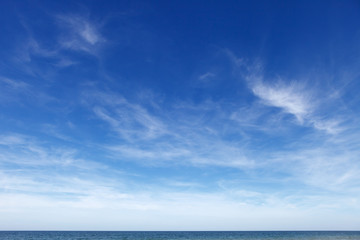 Naklejka na ściany i meble Beautiful blue sky with cirrus clouds over the sea. Skyline.