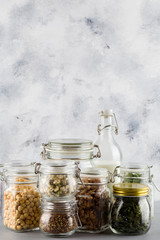 beans , flax seeds, walnuts, milk, bow in glass bowl . healthy food in glass jars on blue background.