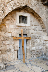 Large wooden cross leaning against a church wall