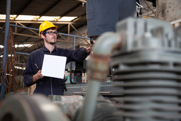 Factory engineer wearing yellow hard hat and checking the machine, Annual maintenance concept