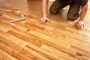 A craftsman lays oak parquet with a click system