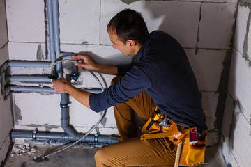 Close-up Of A Male Plumber repairs pipes in the toilet