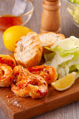 grilled tiger shrimps with spices, sweet and sour sauce, lemon and lettuce