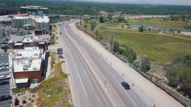 Aeria view: Black car rides on an empty city road in USA