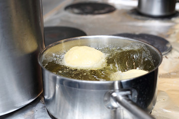 Fat Thursday, traditional sweet pastries. Sweet cake, deep fried yeast dough donut. The cook is frying donuts.