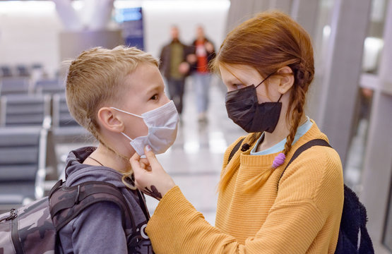 children a boy and a girl at the airport in a protective face mask