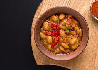 Macedonian traditional dish of vegetables and beans Tavche graver on a black background close-up. copy space