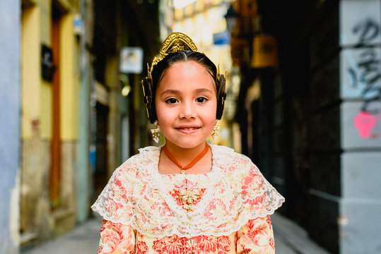 Portrait of a latina fallera girl wearing the traditional valencian costume of Fallas.