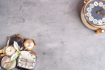 Retro alarm clock on gray dark background top view Flat lay copy space.Old clocks and flower on a...