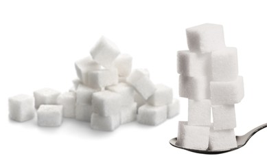 White cubes of sugar on a metal spoon