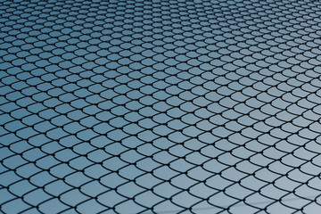 Background of Chainlink fence with blue sky in the background. Backgrounds concept. 