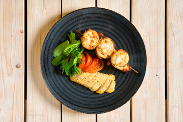 Top view of thin pancakes stuffed with soft cheese rolled and put on skewer