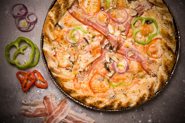 Food ingredients and spices for cooking mushrooms, tomatoes, cheese, onion, pepper, salt,  and delicious italian pizza on black concrete background. Copyspace. Top view. Banner