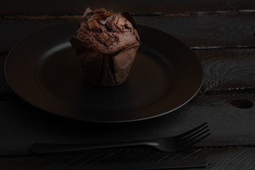 Chocolate cupcake on black wooden background