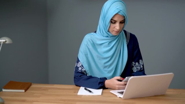 Female muslim student learning at home