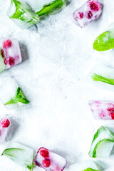 frozen red berries in ice cubes on stone background space for text top view