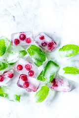 ice cubes with red berries and mint top view gray stone background mockup