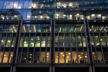 Fragment of the facade of a modern glass skyscraper with reflections and a lantern on the background of a cloudy sky with copy space