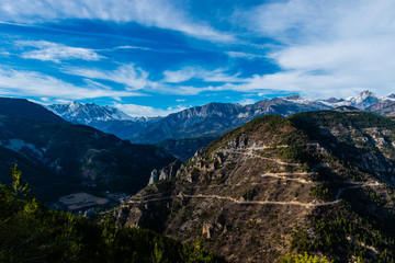 The beautiful view of the French Alps mountain range and a road with high contrast: different types of Alps mountains