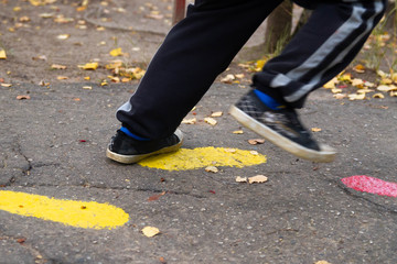 The boy runs on the asphalt. Traces of human paint on the road.