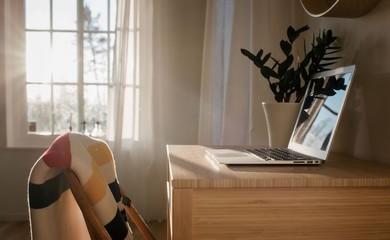 laptop on a desk in a home office with beautiful window light
