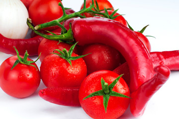 Lots of fresh ripe tomatoes with drops of dew. Close-up background with texture of red hearts with green tails. Fresh cherry tomatoes with green leaves. 