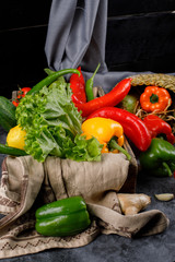 Vegetable basket with green bunch of lettuce and peppers.