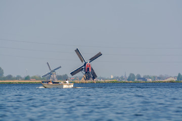 Waterways of North Holland and view on traditional Dutch wind mill, spring landscape