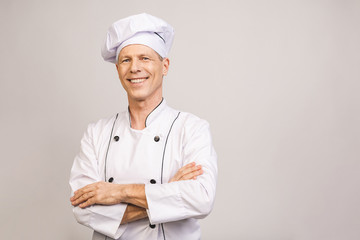 Senior handsome chef cook isolated on grey background.