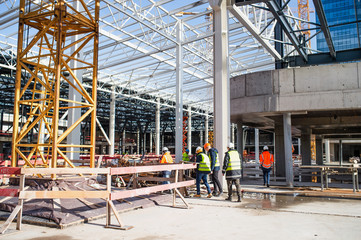 Group of engineers standing on construction site, talking.