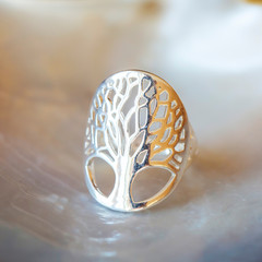 Sterling silver ring with tree in mandala shape on white shell background