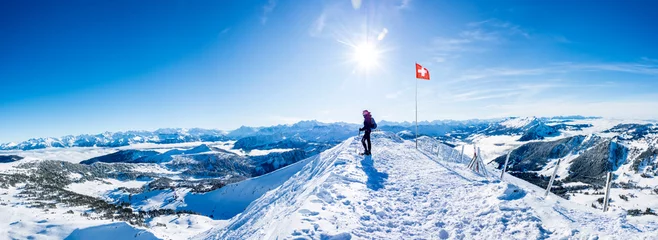 Fotobehang winter sports: snow shoe hiker a the summit of the snowy mountain in the swiss alps. panoramic switzerland mountain range © Simon