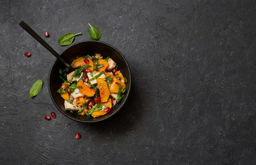 Rustic salad with pumpkin, chicken , spinach and pomegranate seeds