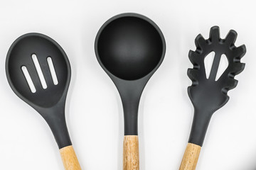 Kitchen tools isolated. Wooden and silicone ladles and spoons for spaghetti.
