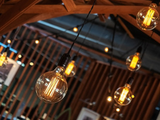 Photo under a tilt from close distance decorative included lamps hanging in the interior of the cafe