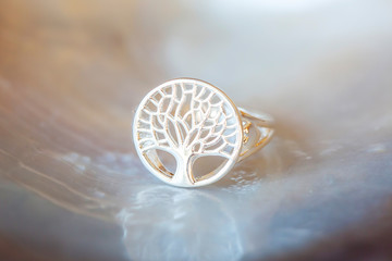 Sterling silver ring with tree in mandala shape on white shell background