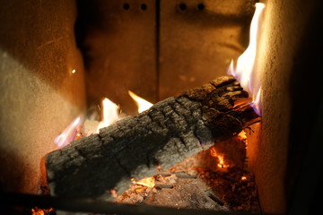 Glowing burning wood log at fire place 