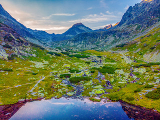 Beautiful waterfall flowing from top of a stone wall. Waterfalll Skok. Mlynicka valley with stone hiking trail. High Tatras mountains in Slovakia © Zedspider