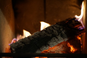 Glowing burning wood log at fire place 