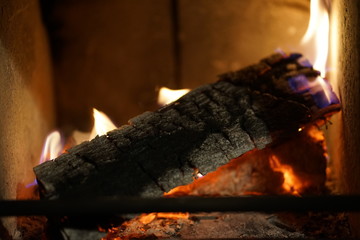 Glowing burning wood log at fire place 