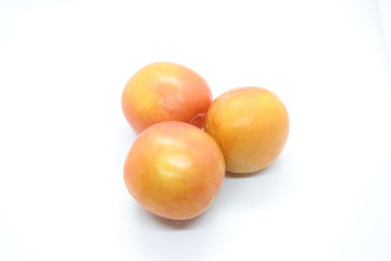 Beautiful delicious orange plums are located on a white background
