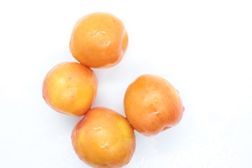 Beautiful delicious orange plums are located on a white background
